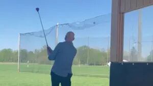 Este hombre intenta un swing en un campo de prácticas de golf y termina con la pelota en la cara