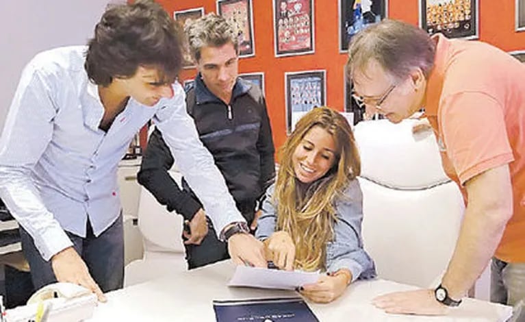 Florencia Peña lee el contrato de Ideas del Sur, junto a Chato Prada, Fede Hoppe y su representante. (Foto: diario Clarín)