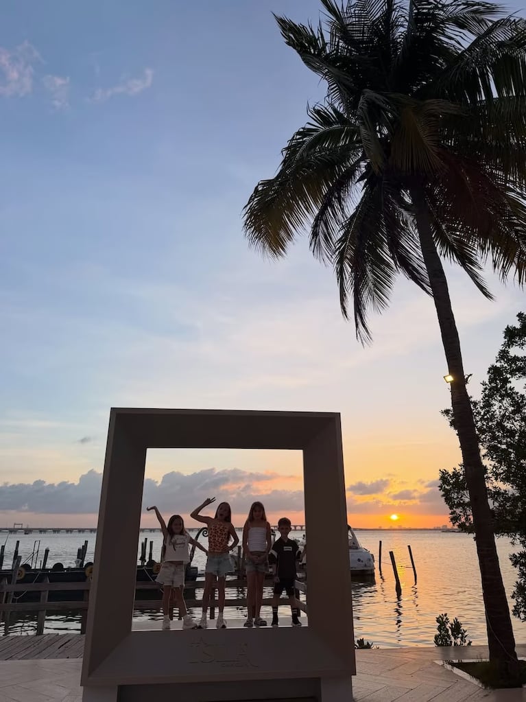 Al atardecer, los chicos posaron frente al agua enmarcados en una estructura cuadrada blanca con el sol hundiéndose en el horizonte.