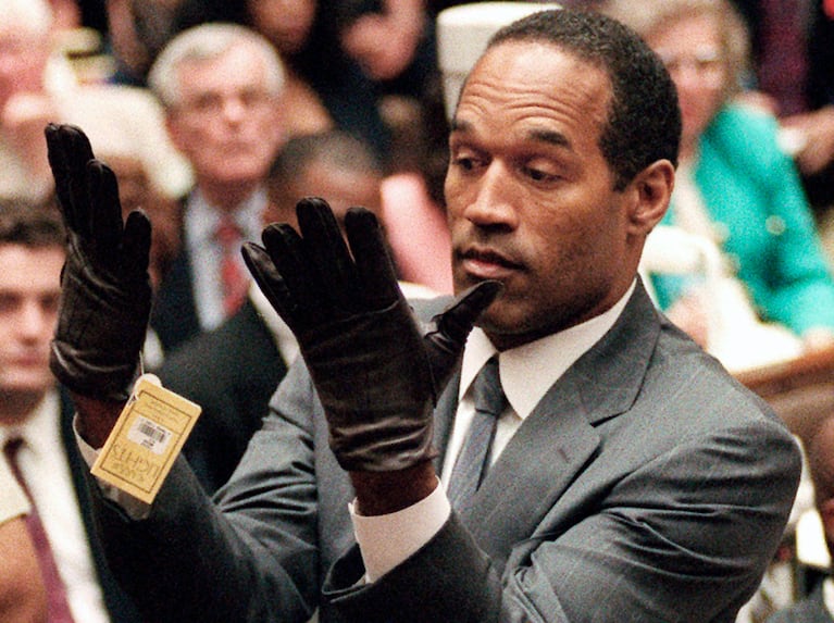 ARCHIVO - En esta foto del 21 de junio de 1995, O.J. Simpson alza sus manos al ponerse unos guantes ante el jurado en su juicio por doble asesinato en Los Ángeles. Simpson ha fallecido. Tenía 76 años. (Vince Bucci/Pool Foto vía AP, archivo)