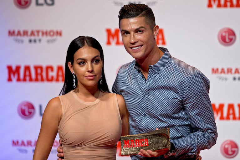 ARRCHIVO - Foto del 29 de julio del 2019, el jugador de la Juventus Cristiano Ronado posa con su pareja, la modelo Georgina Rodríguez en Madrid. (AP Photo/Paul White, File)