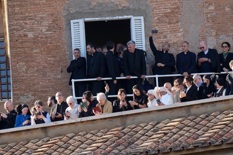 El clero y los laicos se encuentran en un balcón en la azotea después de que saliera humo blanco de la chimenea de la Capilla Sixtina, donde 133 cardenales se reunieron en el segundo día del cónclave para elegir al sucesor del difunto Papa Francisco, en el Vaticano, el jueves 8 de mayo de 2025. (AP Foto/Luca Bruno)