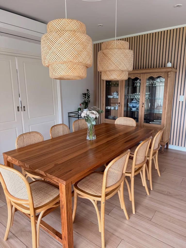 El comedor, con mesa de madera oscura, sillas estilo Thonet y un vajillero antiguo de fondo. Foto: Instagram @noeliamarzolok