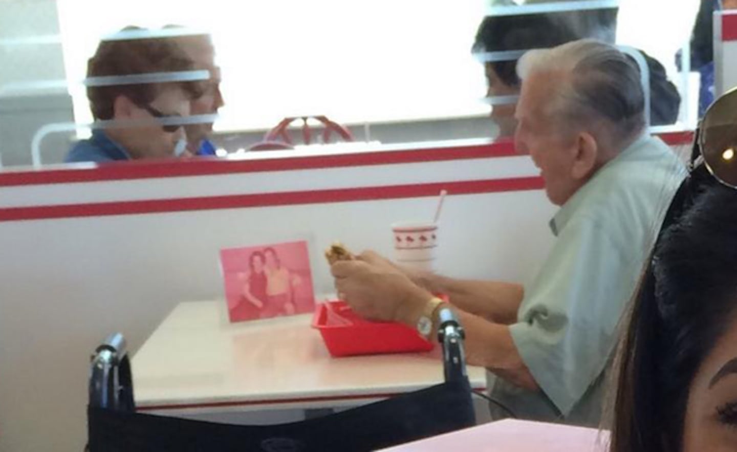 El hombre que cena junto a la foto de su esposa fallecida. (Foto: @Maaadina)