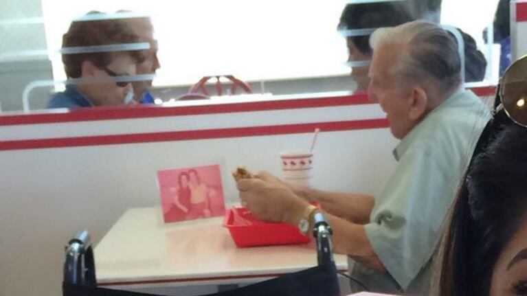 El hombre que cena junto a la foto de su esposa fallecida. (Foto: @Maaadina)