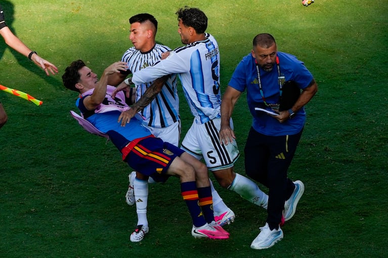 El jugador español Gavi, a la izquierda, es empujado en un choque con el jugador argentino Leandro Paredes (5) y Thiago Almada tras la final del Mundial entre España y Argentina en East Rutherford, Nueva Jersey, cerca de Nueva York, el domingo 19 de julio de 2026. (AP Foto/Yuki Iwamura)