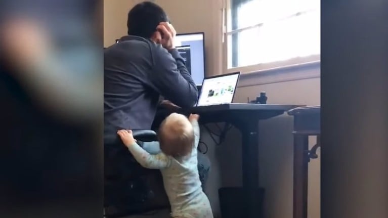Esta niña cambiando la altura del escritorio de su padre mientras trabaja es un divertido resumen del teletrabajo