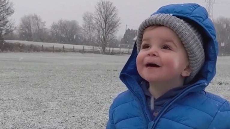 Este niño de un año de edad está asombrado al ver la nieve por primera vez