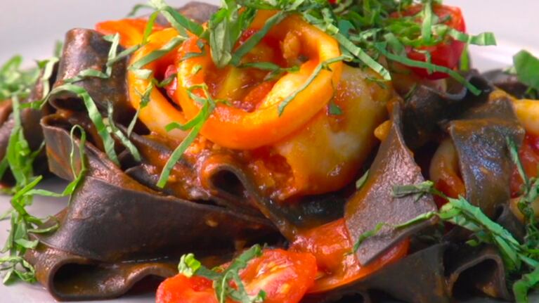 Fideos con tinta de calamar, acompañados de una salsa con marisco y tomate.
Foto: CucinareTV