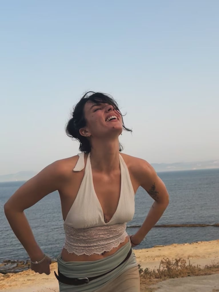 Gimena Accardi sonríe al aire libre con el mar de fondo durante su estancia en España