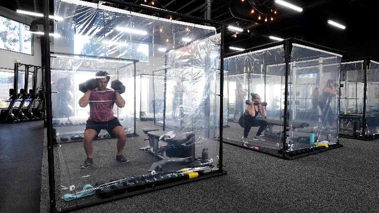 Gimnasio de California pone cabinas de plástico para cada cliente. Foto: AFP.