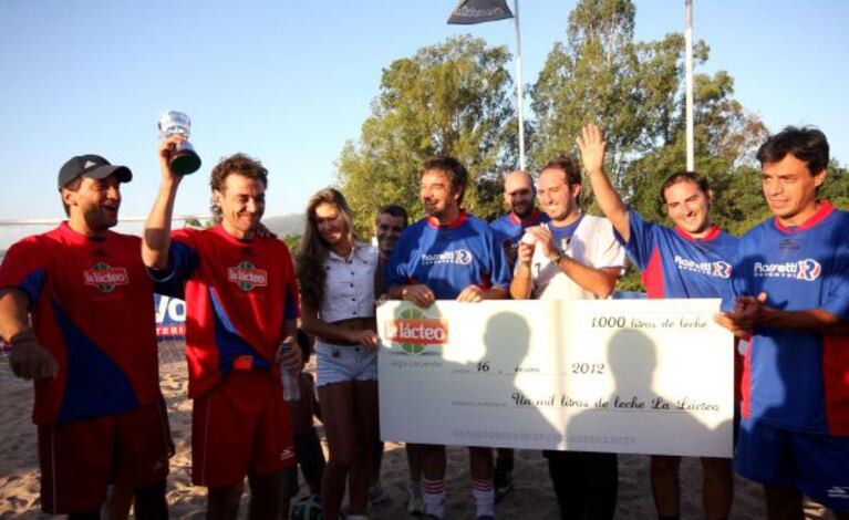 Gustavo Conti junto a Pedro Alfonso, quien alza la copa del campeón y recibe la donación de 1.000 litros de leche (Foto: La voz)