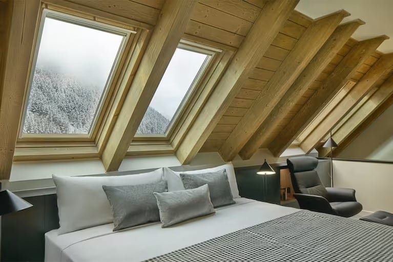 La Suite Messi ofrece un ambiente cálido y elegante con detalles en madera y una cama king size
