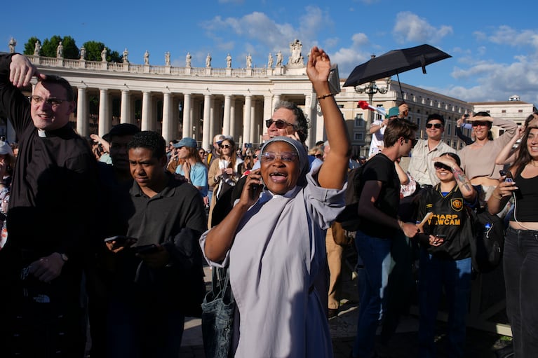 Los fieles celebran después de que apareció humo blanco de la chimenea de la Capilla Sixtina, donde 133 cardenales se reunieron en el segundo día del cónclave para elegir al sucesor del fallecido papa Francisco, en el Vaticano, el jueves 8 de mayo de 2025. (AP Foto/Emilio Morenatti)