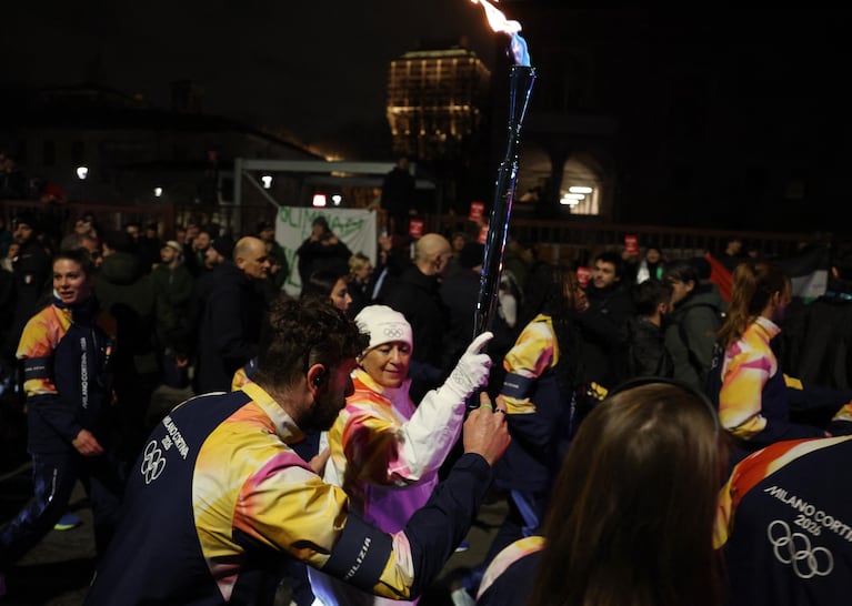 Milano Cortina 2026 Winter Olympics - Anti-Israel Protest as the Olympic flame arrives in Milan - Milan, Italy - February 5, 2026 A torchbearer carries the Winter Olympics flame past the Anti-Israel Protest REUTERS/Claudia Greco