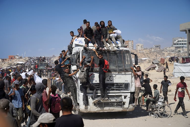 Palestinos cargan sacos de harina extraídos de un convoy de ayuda humanitaria que se dirigía a Ciudad de Gaza, el viernes 1 de agosto de 2025, en las afueras de Beit Lahiya, en el norte de la Franja de Gaza. (AP Foto/Jehad Alshrafi)