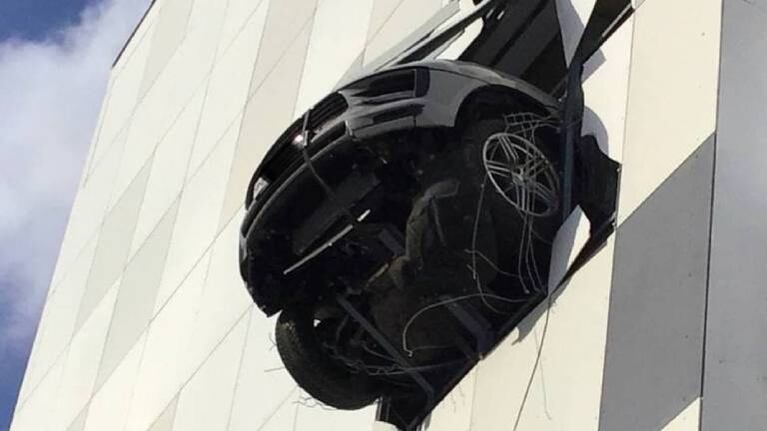 Porsche atraviesa la pared de un estacionamiento en edificio y queda colgado en el aire