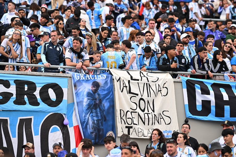Soccer Football - International Friendly - Argentina contra Benín - Estadio Monumental, Buenos Aires, Argentina - 6 de octubre de 2026. Aficionados argentinos en las gradas con una bandera que muestra a Lionel Messi y otra pancarta con un mensaje sobre las Islas Malvinas que dice "Las Malvinas son Argentinas". REUTERS/Rodrigo Valle