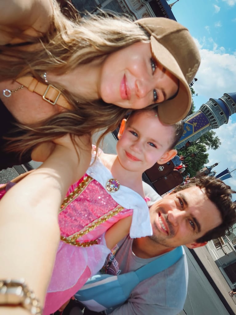 Stephanie Demner y Guido Pella posan felices junto a su hija frente al castillo de Disney