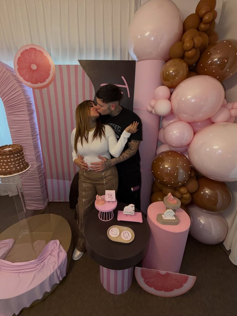 Tamara Báez y Thiago Martínez compartieron un beso en medio del festejo, en una imagen donde él aparece con las manos sobre la panza de ella. Crédito Instagram.
