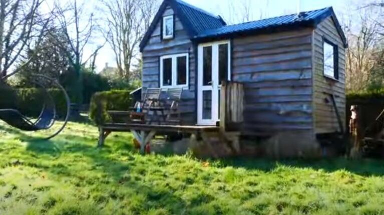 Un adolescente construye su propia casa de madera en el jardín de la casa de sus padres