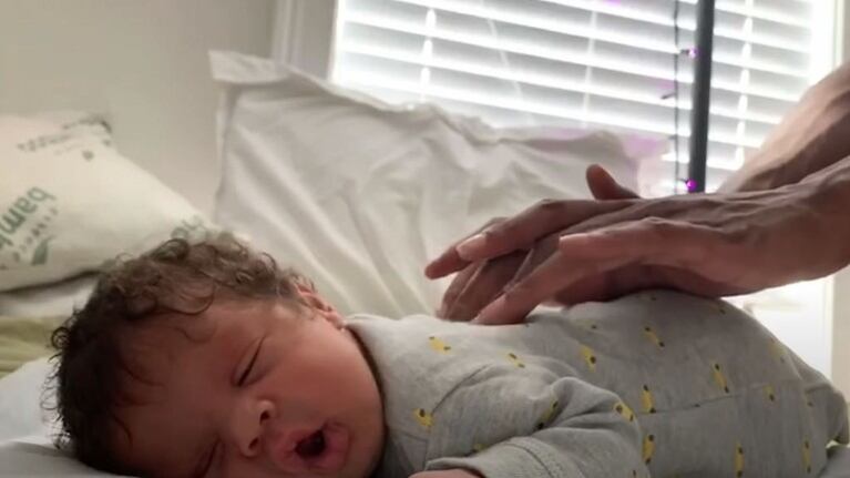 Un bebé reacciona al masaje que le hace su padre