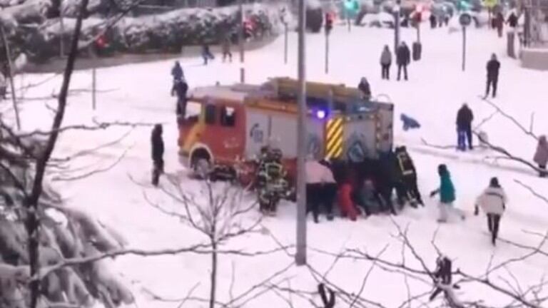 Un grupo de ciudadanos rescata un camión de bomberos de Madrid atrapados en la nieve