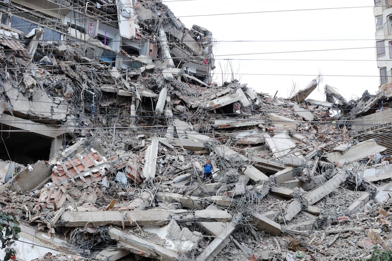 Un hombre camina entre los escombros de un edificio que se derrumbó debido a los sismos ocurridos el día anterior en La Guaira, Venezuela, el jueves 25 de junio de 2026. (AP Foto/Pedro Mattey)