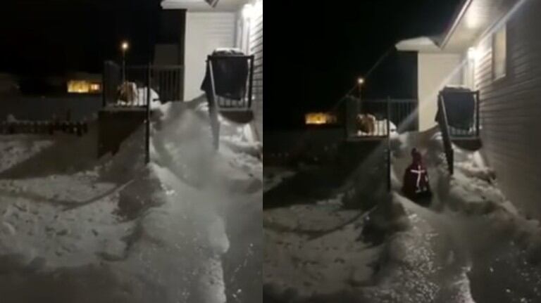 Un hombre construye un tobogán de hielo con la nieve acumulada en el jardín de su casa
