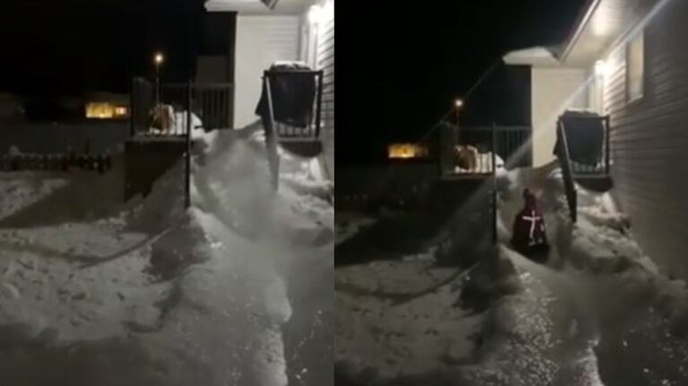 Un hombre construye un tobogán de hielo con la nieve acumulada en el jardín de su casa