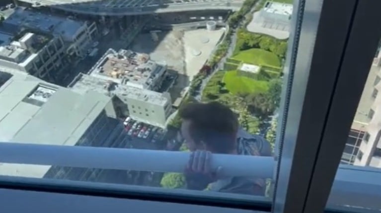 Un joven temerario que estaba escalando un rascacielos fue captado por un empleado que trabaja en la enorme estructura