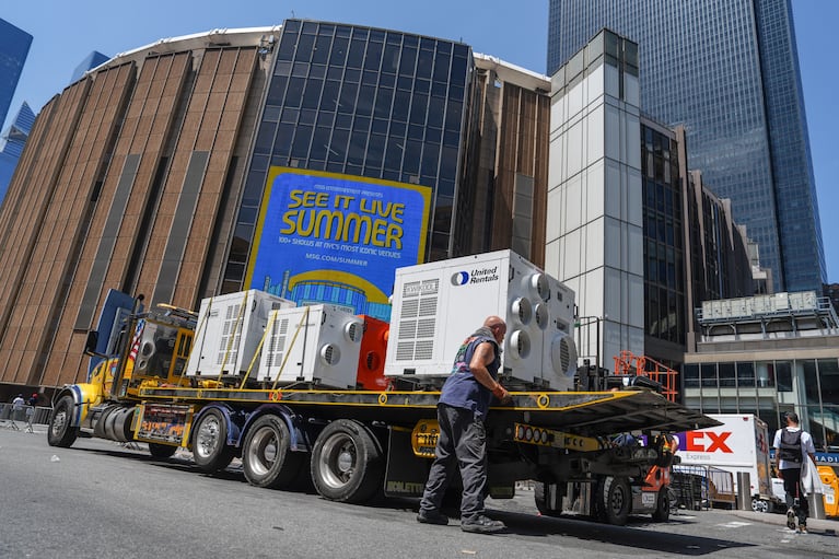 Un trabajador descarga unidades de aire acondicionado portátiles frente al Madison Square Garden, ante la anunciada boda entre la cantante Taylor Swift y el jugador de la Liga Nacional de Fútbol Americano Travis Kelce, el jueves 2 de julio de 2026, en Nueva York. (Foto AP/Ryan Murphy)