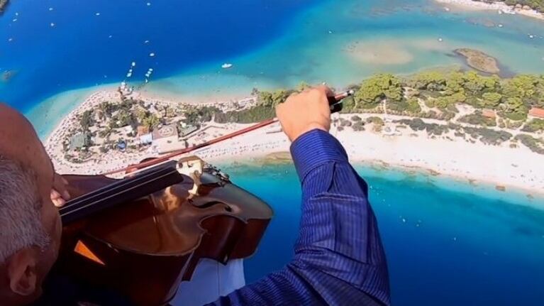 Un violonchelista de 60 años toca el himno nacional estadounidense mientas hace parapente