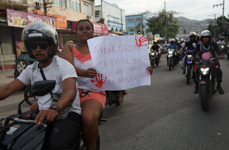 Una mujer sostiene un cartel mientras monta una motocicleta durante una protesta, al día siguiente de un letal operativo policial contra el narcotráfico en la favela de Penha, en Río de Janeiro, Brasil, el 29 de octubre de 2025. REUTERS/Ricardo Moraes.