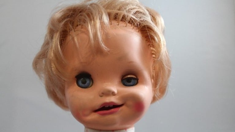 una muñeca antigua cambia su cara al girarle el brazo