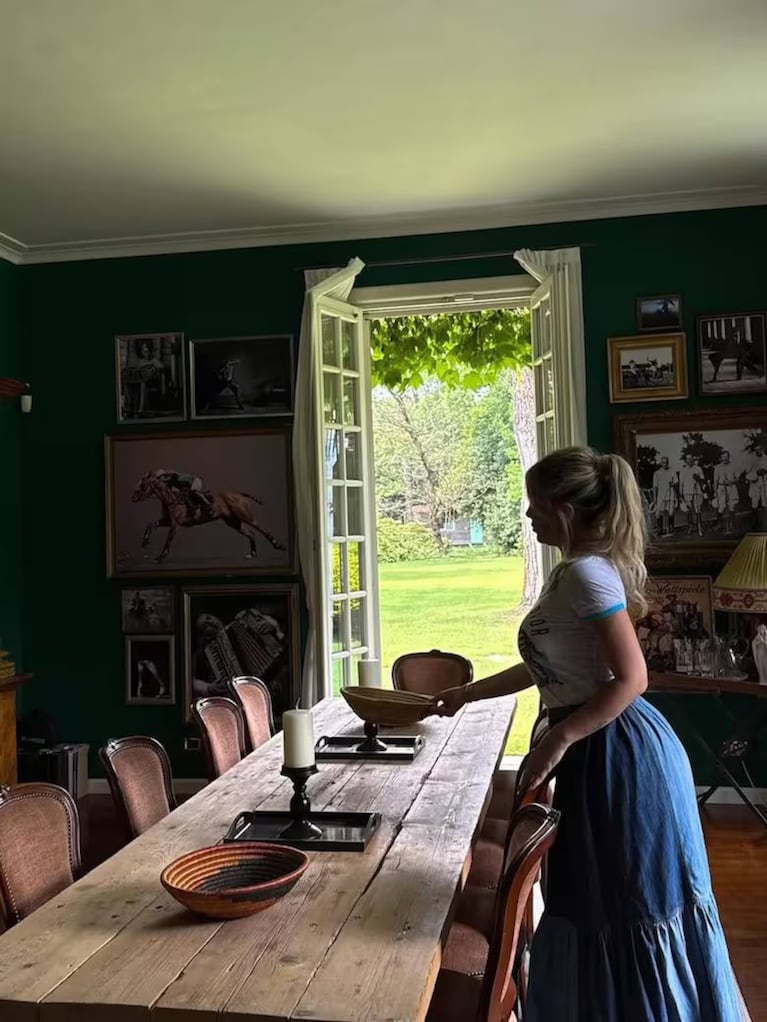 Wanda Nara, en el comedor de su casa de campo en Milán, con paredes verdes, cuadros ecuestres y una gran mesa de madera rústica.  Fuente: Instagram/@wandanara