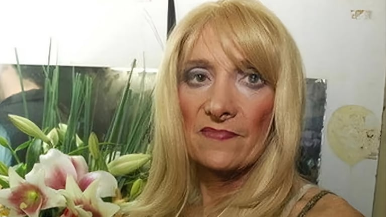 Zulma Lobato en una foto de archivo, con peluca rubia y un ramo de flores de fondo.
