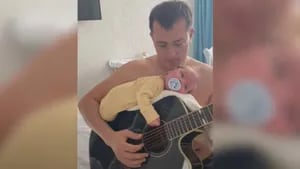 La original forma de este padre de dormir su bebé: tocar la guitarra...¡con el bebé encima!